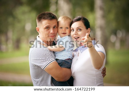 happy young family mom dad and baby in the park