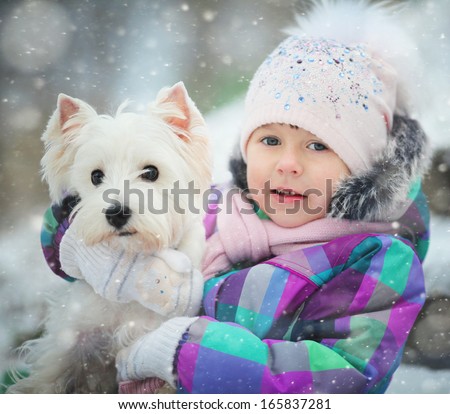 girl playing with a white dog winter snow happiness
