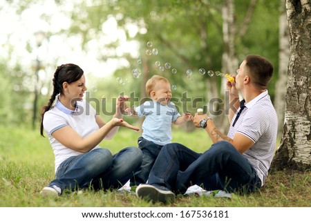 happy young family mom dad and baby in the park