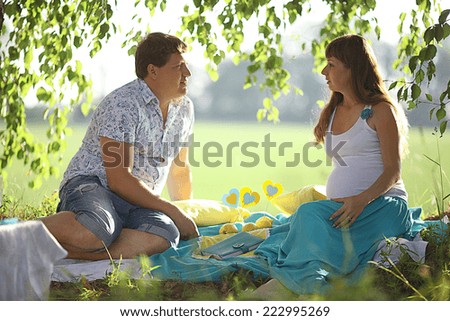 man and a pregnant woman happy nature