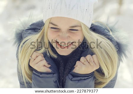 portrait of a young blonde girl in winter forest in the park