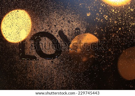 inscription love on the wet glass at night