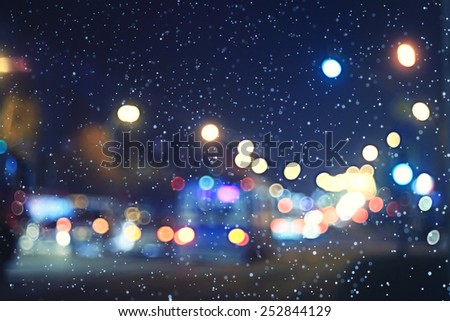blurred night background city traffic road city lights winter snow glare
