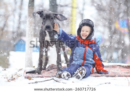 little boy with a big black dog breed