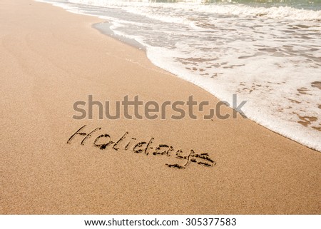 DRAWING ON THE SANDY BEACH WITH SEA WAVE IN SUMMER