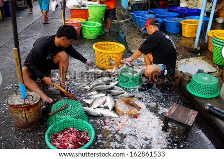 CHONBURI, THAILAND-NOVEMBER 10, 2013: Workers are knitted fish scales at Angsila fish market, where innumerable fishing boats are gathering, located 5 km from Chonburi, Thailand. November 10 2013