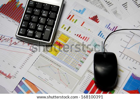 Business finance chart with number pad and mouse on table.