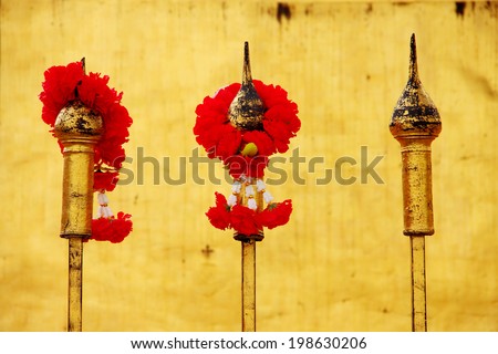 Red rose garland on fence at temple, Thailand.