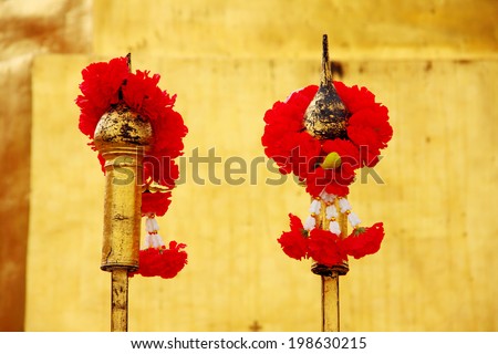 Red rose garland on fence at temple, Thailand.
