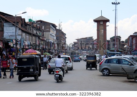 SRINAGAR, INDIA - JULY 29, 2015: Traffic around clock tower in Lal Chowk. It is one of the most popular shopping place with shops and vendors in Srinagar, Indian state of Jammu & Kashmir. JULY 29 2015