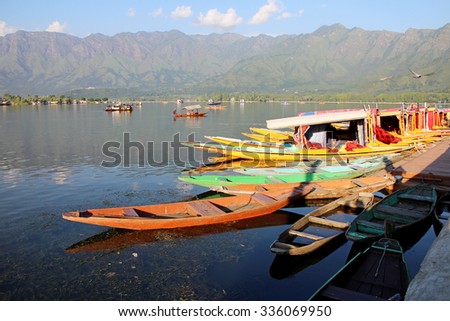 SRINAGAR, INDIA - JULY 29, 2015: Small wooden boats are called Shikara, that local people and tourist use for traveling and transportation in Dal lake, Srinagar, Jammu & Kashmir. JULY 29 2015