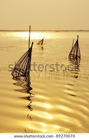 Bamboo fish-trap in golden lake, Thailand.