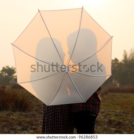 shadow of man and women behind the umbrella