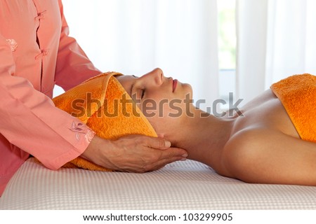 Closeup of a beauty therapist and her young client in orange uniform and towels