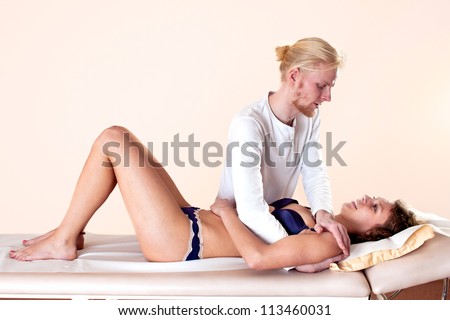 Practitioner applying sideways pressure on a patient\'s arm and shoulder to assist in the straightening, resetting, correction and reduction of a dislocation