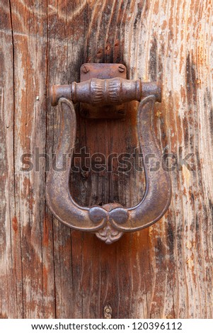 Antique door knocker, beautiful shape and ornament, rusty.