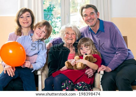Family posing with grandma smiling and looking happy