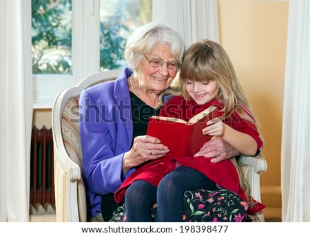 Grandmother and Young Girl Reading together having fun.