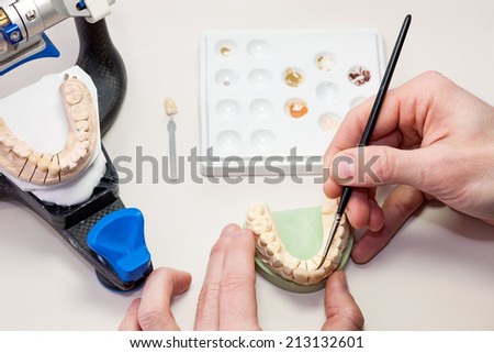 Making facial dental prosthesis for patients with oral problems like missing teeth or and missing soft or hard structures of the jaw and palate. Isolated on white table.