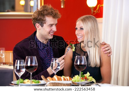 Close up Smiling Young White Couple Dinner Date - Guy Feeding His Partner with Vegetable Salad.