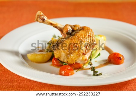 Fried pearl chicken, guinea fowl, on red lentils with vegetables and port wine sauce, decorated with very thin grilled crispy potato stripes.
