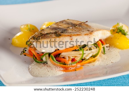 White fish fillet of perch in fluffy sauce, decorated with thyme.