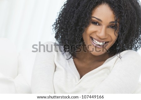 Portrait of a beautiful middle aged African American woman sitting at home relaxing smiling or laughing