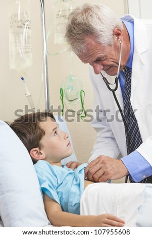 Senior mmale doctor with stethoscope examining a young boy child in a hospital bed