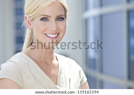 Natural light portrait of a beautiful blond woman or businesswoman with blue eyes in modern city