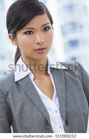 Outdoor portrait of a beautiful young Asian Chinese woman or businesswoman in smart business suit