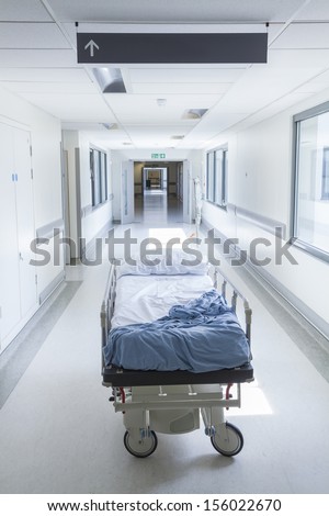 Bereavement, Death Or Loss Concept Shot Of Empty Bed, Gurney Or Stretcher With Drip In Hospital Corridor