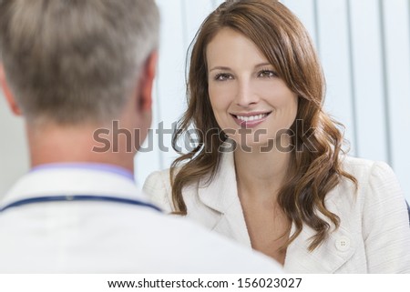 Happy smiling middle aged woman patient or colleague meeting consultation appointment with male doctor in hospital or surgery office