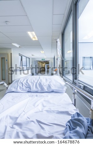 Bereavement, death or loss concept shot of empty bed, gurney or stretcher with drip in hospital corridor
