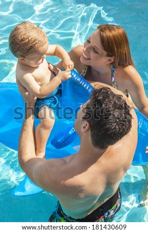 A happy family of mother, father, son, parents & boy child, having fun playing in a swimming pool with inflatable dolphin