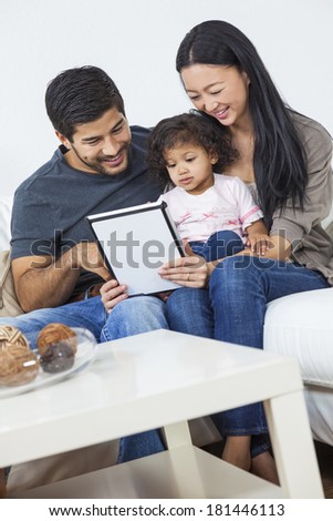 A happy Young Asian family, man and woman couple with young baby child using a tablet computer at home