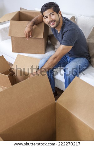 Asian Chinese Korean man packing or unpacking boxes and moving into a new home.