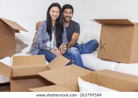 Asian Chinese couple packing or unpacking boxes and moving into a new home.