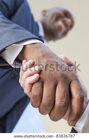 African American businessman or man shaking hands with a caucasian colleague doing a business deal