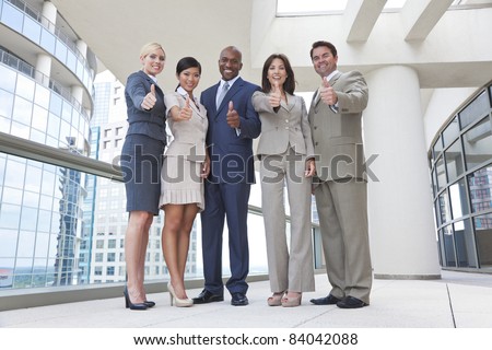 Successful positive interracial group of business men & women, businessmen and businesswomen team, giving thumbs up