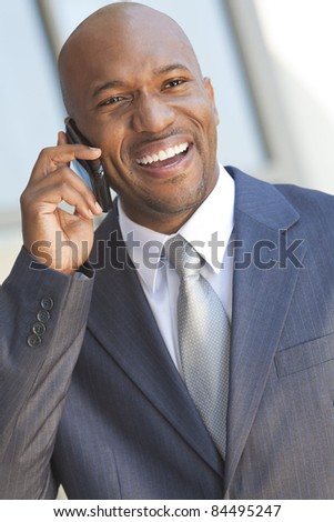 Successful African American businessman or man in a suit in a modern city talking on his cell phone