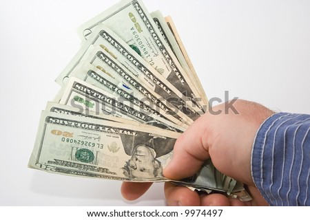 A hand holding a wad of cash, in twenties