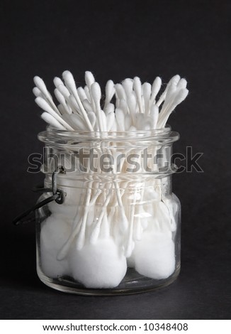 An old jar filled with cotton balls and swabs