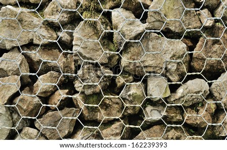 various stones carefully aranged in an iron net to make a wall