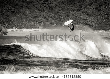 surfer getting big air and wiping out in rough indian surf