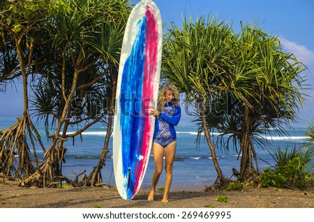 Young Woman Surfer Girl with Surfboard in Bali.