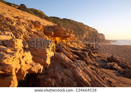 Sandstone breaking down at the beach under sunset light. Meco, Sesimbra, Portugal.