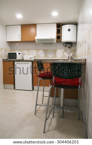Renewed small kitchen. Counter with high chairs. Cupboards, small refrigerator, microwave oven, fumes extractor and water heater.