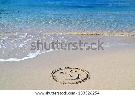 Smile face written in the sand in the beach in Cala Vadella in Ibiza, Spain