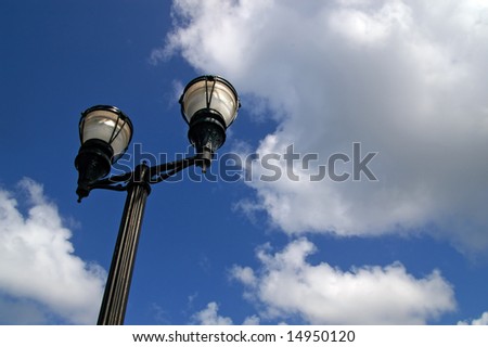 old vintage street lamp against cloudy sky