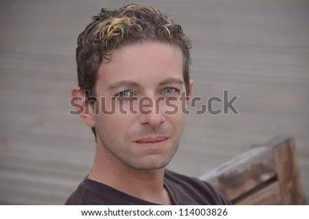 Good looking blue eyed guy sitting on bench